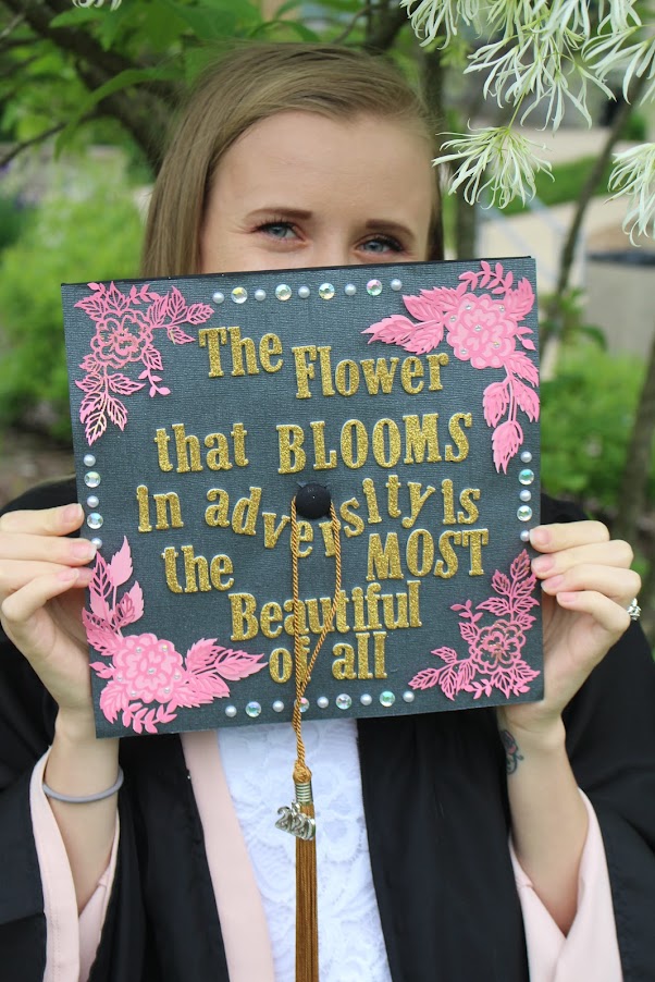 Masha is pictured here with her decorated graduation cap which reads 'The flower that blooms in adversity is the most beautiful of all.'—a shortened version of a quote from the Disney movie Mulan. The quote resonates with Masha's perception of herself as having achieved something truly special, by persevering and succeeding despite some of the greatest challenges. She hopes to inspire others who have faced challenging life circumstances to pursue their dreams and to not hesitate to utilize the resources available to them. There is no shame in getting help and assistance from others.